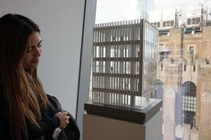 Woman looking at architectural model near a window.