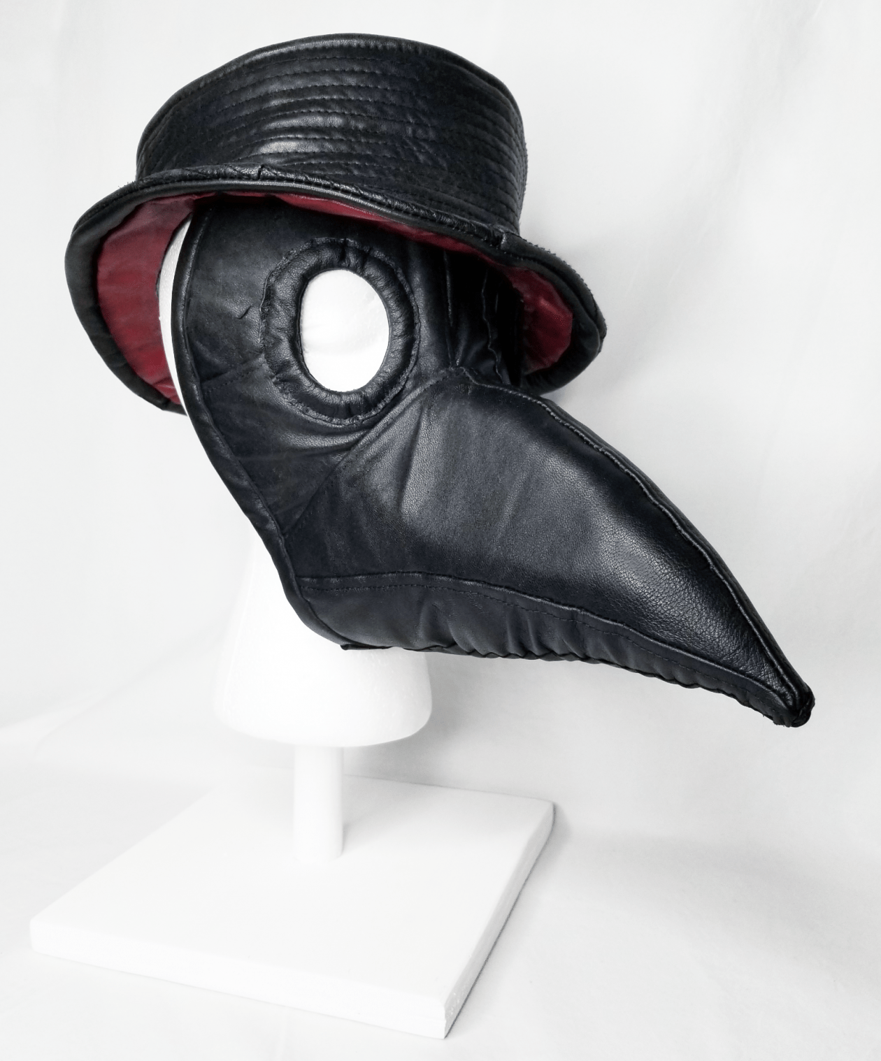 A black leather beaked face mask with matching hat.