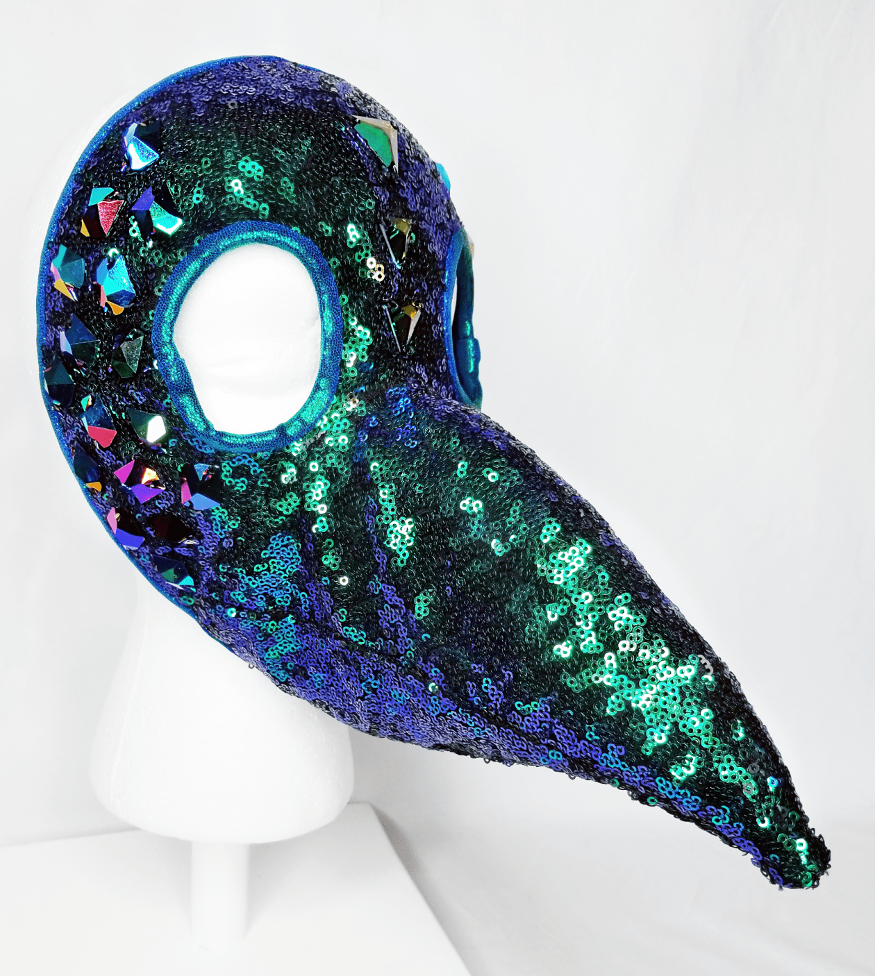 A green and blue sequin beaked mask