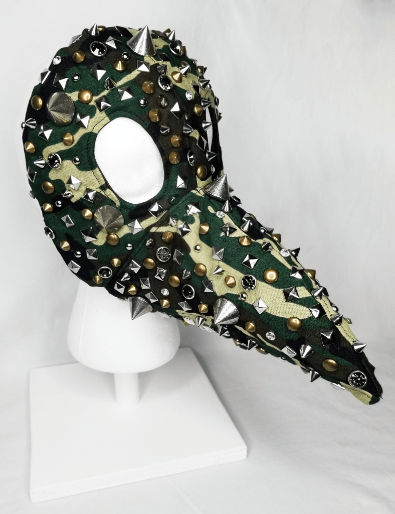 A beaked camo mask covered in studs
