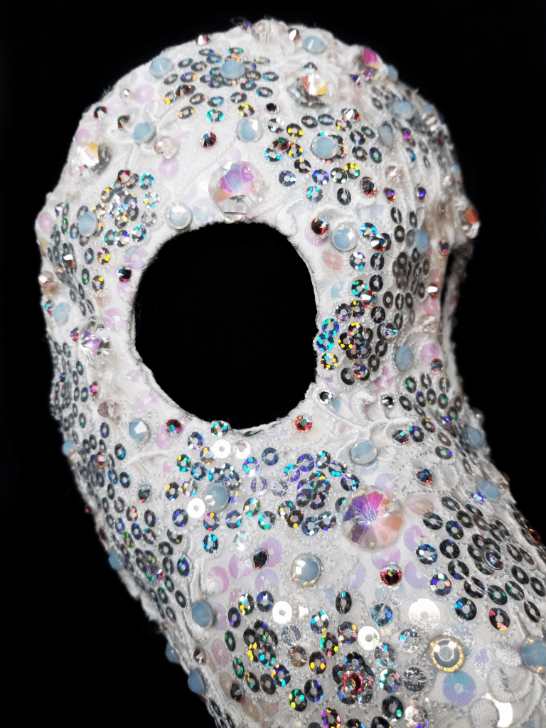 Details of a white and silver beaked mask