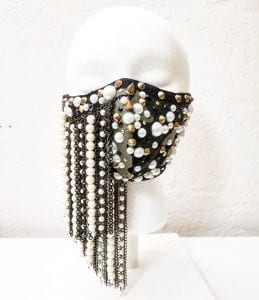 A face mask embellished with studs, spikes, and pearls.