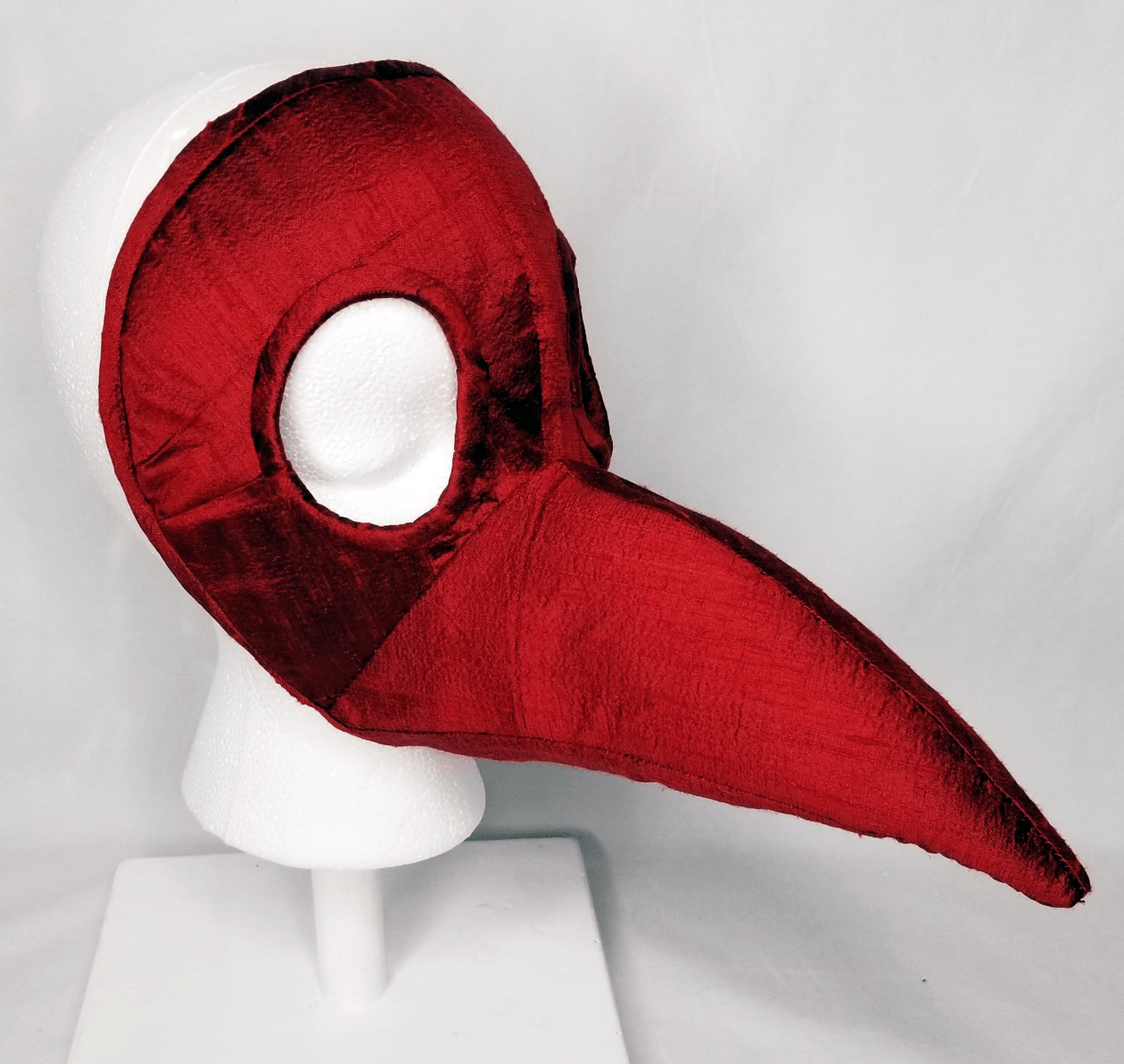 A red beaked mask on a head form