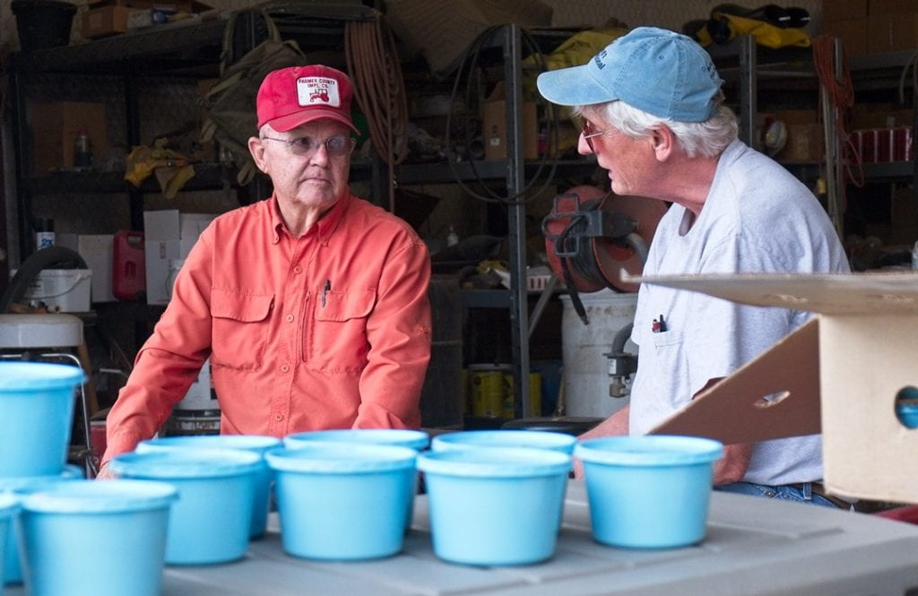 Cornell University Entomologist Elson Shields, right, talks with farmer Gary Frost as cups filled with biocontrol nematodes from New York State await application on Frost's farm in Dalhart, TX.