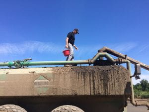 man standing on manure truck