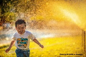 Child running in the sprinklers