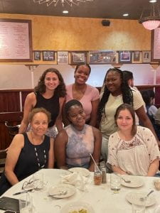 6 women posing for a picture at a table in a restaurant
