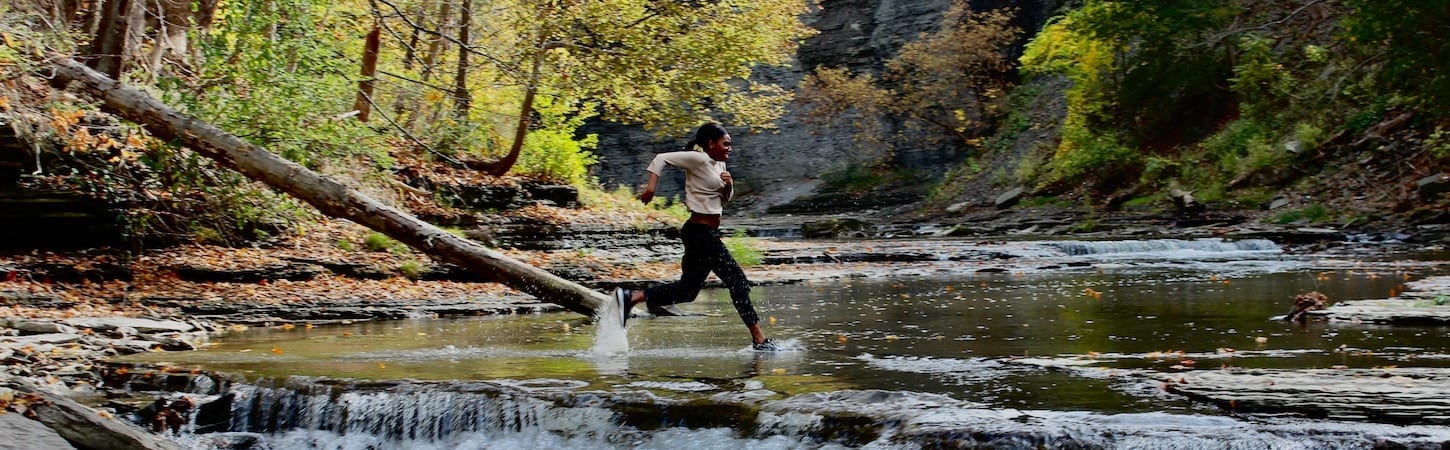 Photo of person running next to waterfall