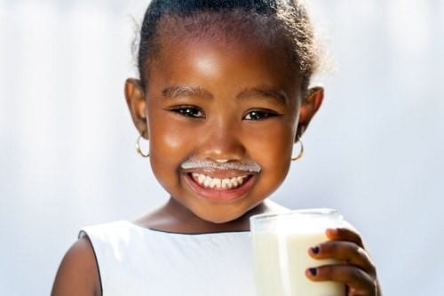 Young girl with milk mustache.