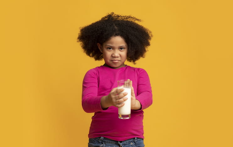 Young African American girl refusing milk