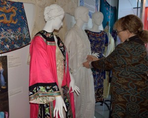 Dr. Jirousek puts finishing touches on the 2013 exhibit, “Chinese Traditional Dress and Its Influence (1840-1960).”  Photo by Mark Vorreuter.