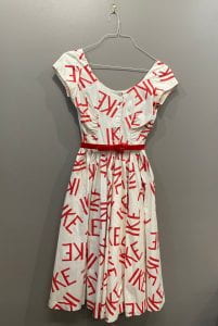 White dress with the word "IKE" written all over it in large, red letters.
