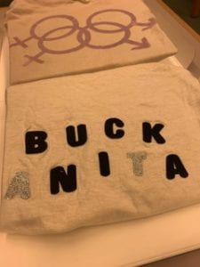 T-shirt that says "Buck Anita." The letters are black save for the first "A" and "T" in Anita, which are a glittery silver.