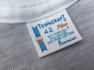 Clothing tag from a t-shirt. Reads "Towncraft, 42, Plus, 50% Fortrel Polyesterm 50% Pima Cotton, Penneys."