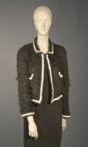 1998 Chanel jacket on mannequin. Jacket is dark grey with white trim around edges and pockets.