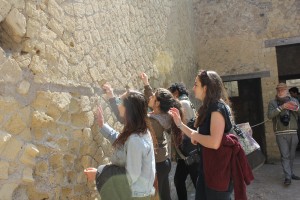 Urban Planning students inspect ancient stonework in Herculaneum.