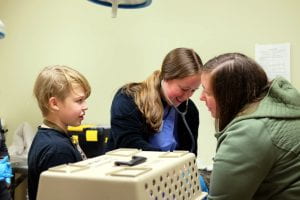 CU vet student volunteering at Schuyler Wellness Clinic discusses procedures with your pet owner