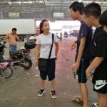 students talk to a buyer at a vegetable market