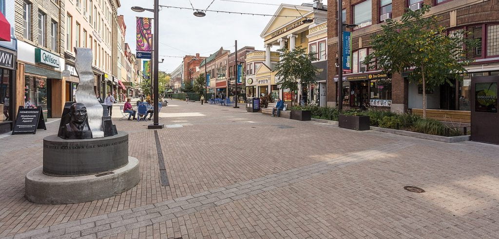bricked pedestrian area flanked by retail buildings 