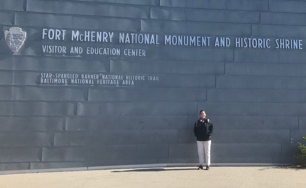 woman standing in front of a wall that reads "For McHenry National Monument and Historic Shrine"