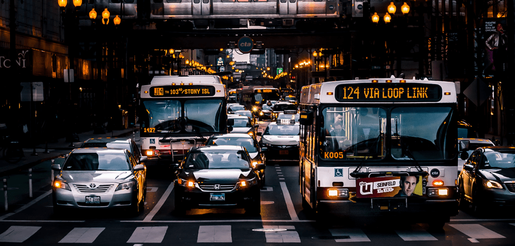 photo of street with buses and cars at sunset