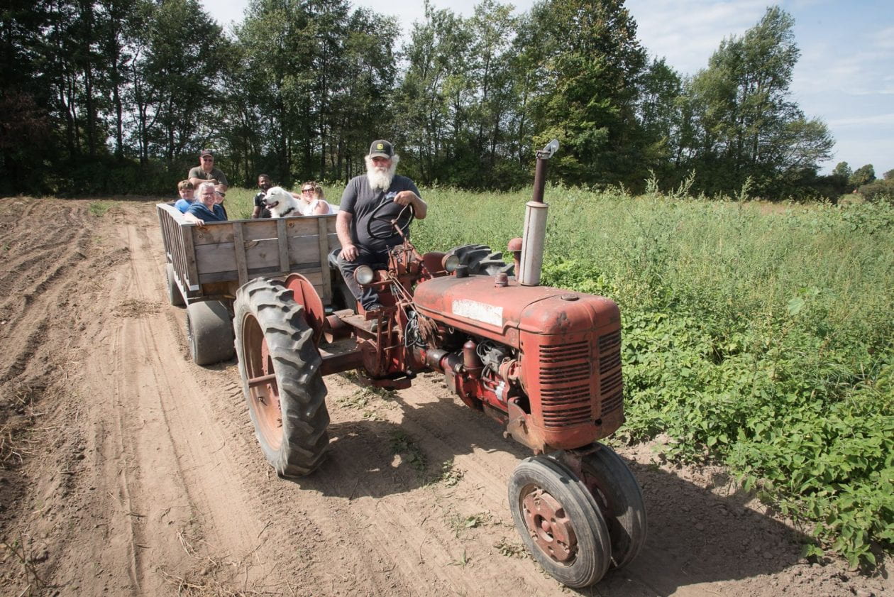 A man drives a tractor wagon ride.