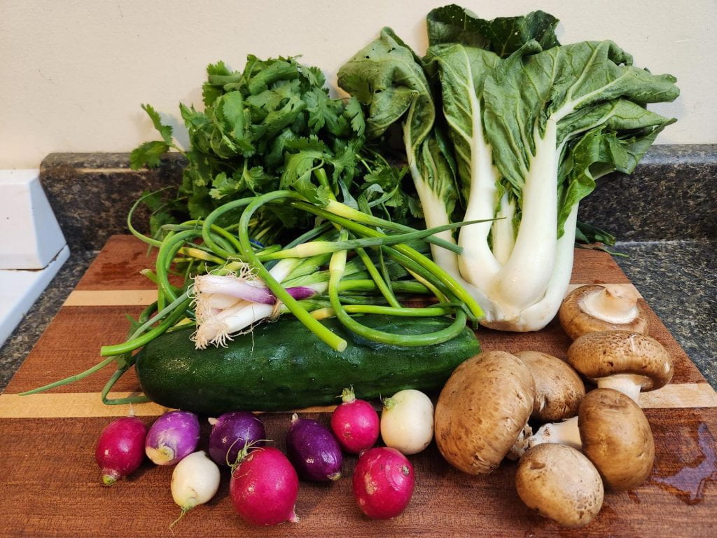 A photo of various different vegetables on a cutting board. 