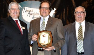 Travis Park (center) accepts the Outstanding Cooperation Award from Ken Couture, 2011-2012 NAAE President, and Mike Williams, Association Sales Director for Forrest T. Jones, the sponsor of the Outstanding Cooperation Award, November 30 at the NAAE annual convention in Atlanta.