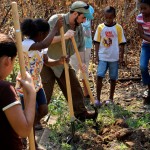 Bryan Sobel, MS candidate in the Graduate Field of Horticulture, demonstrates how to break ground for a garden bed. The students built two gardens outside the school in Barranco, a Garifuna Village in the Toledo District in southern Belize.