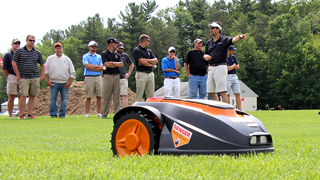 Rossi (right) explains robotic mower research at Bluegrass Lane Turf Field Day in 2015.