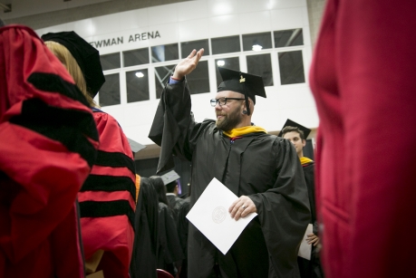Justin France waves to family and friends after receiving recognition for earning his master's degree in horticulture. (Photo: Jason Koski/University Photography)