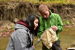 Students Stevanica Augustine, left, and Jonas Soe examine invertebrates along the streams that feed into Lake Trema