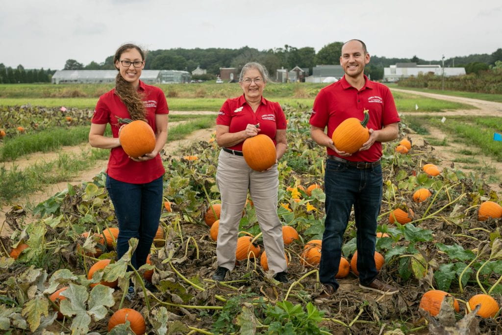 Meg, Collin and summer assistant Claire in a pumpkin field