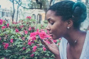 A black woman stopping to smell the flowers