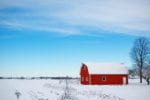 Red barn with blue sky and snow on the ground