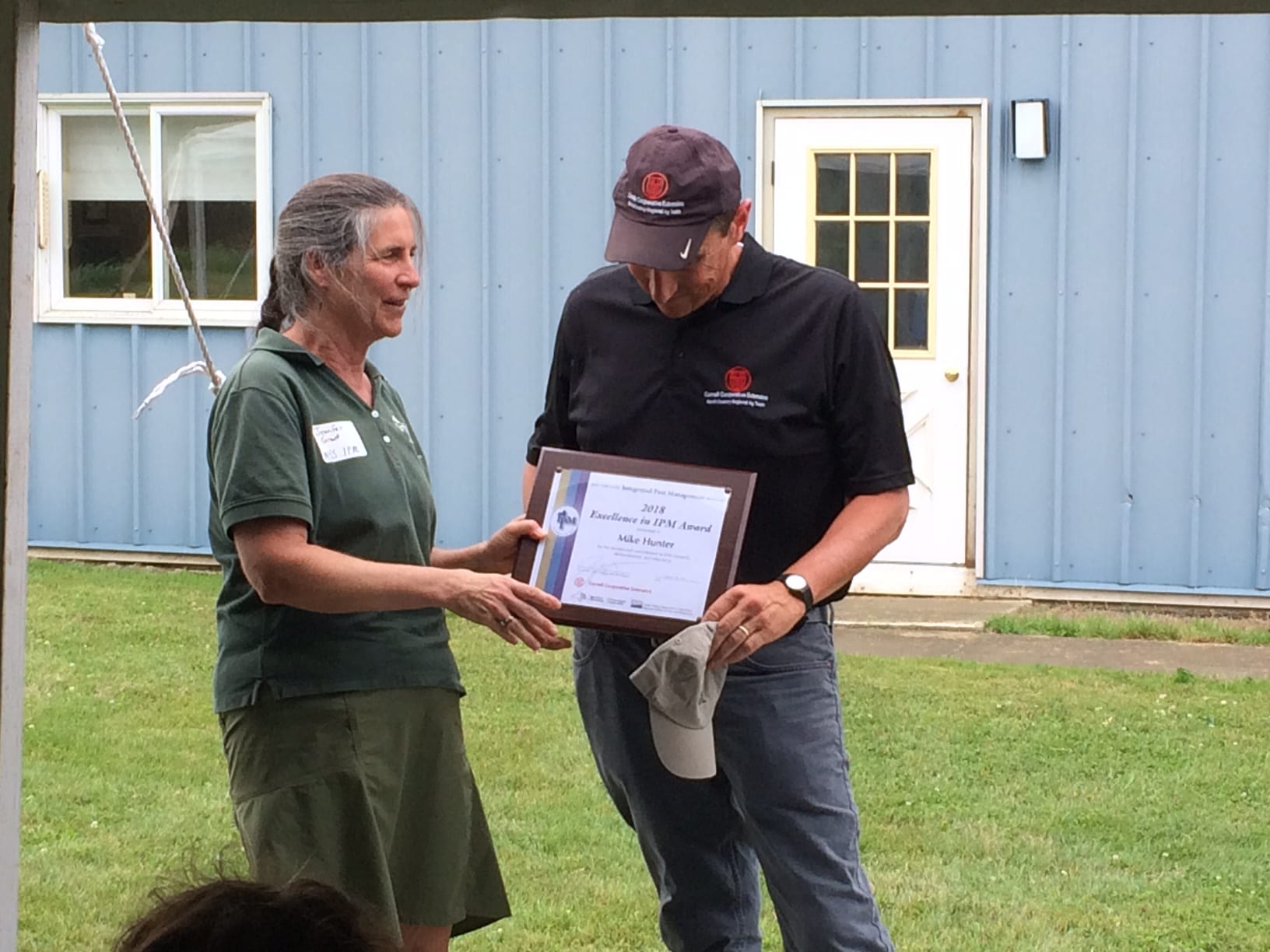 Photo shows Dr. Jennifer Grant awarding a plaque to Mike Hunter for his Excellence in IPM Award.