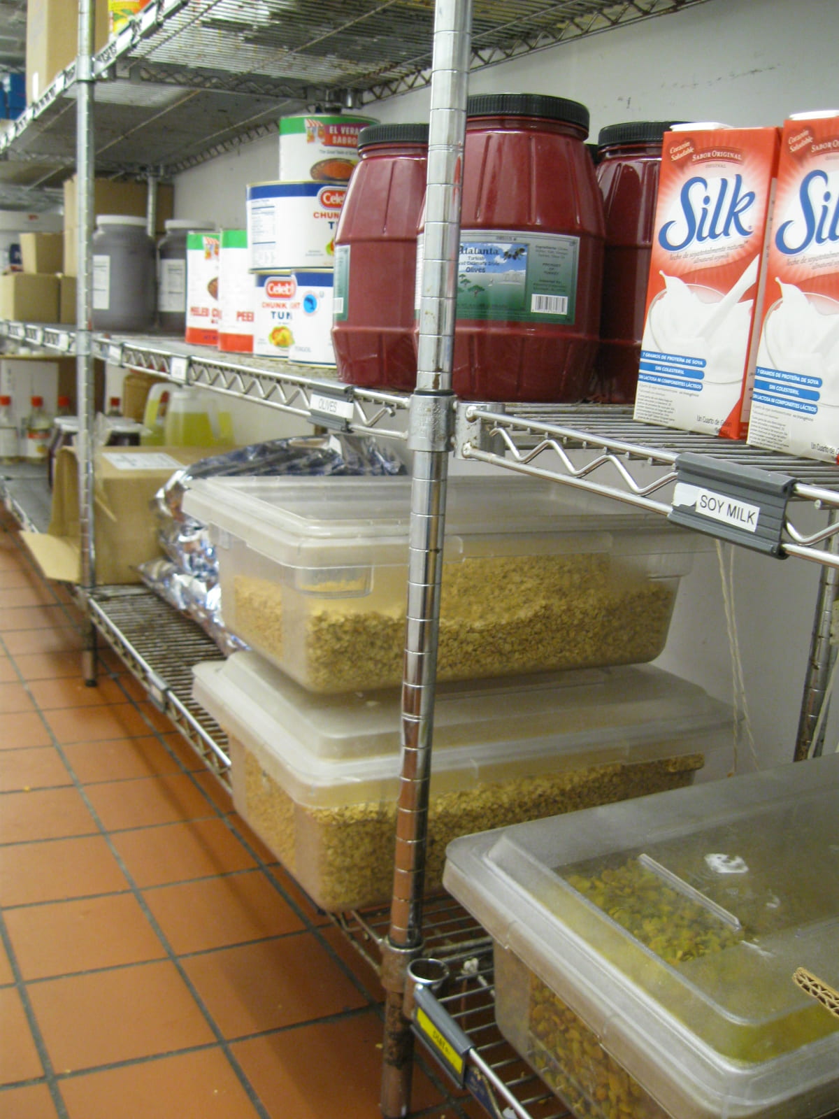 Photo shows metal storage shelves with proper spacing and pest-resistant storage of food items. Spacing the metal shelves in a way that allows cleaning and reduces pest habitat