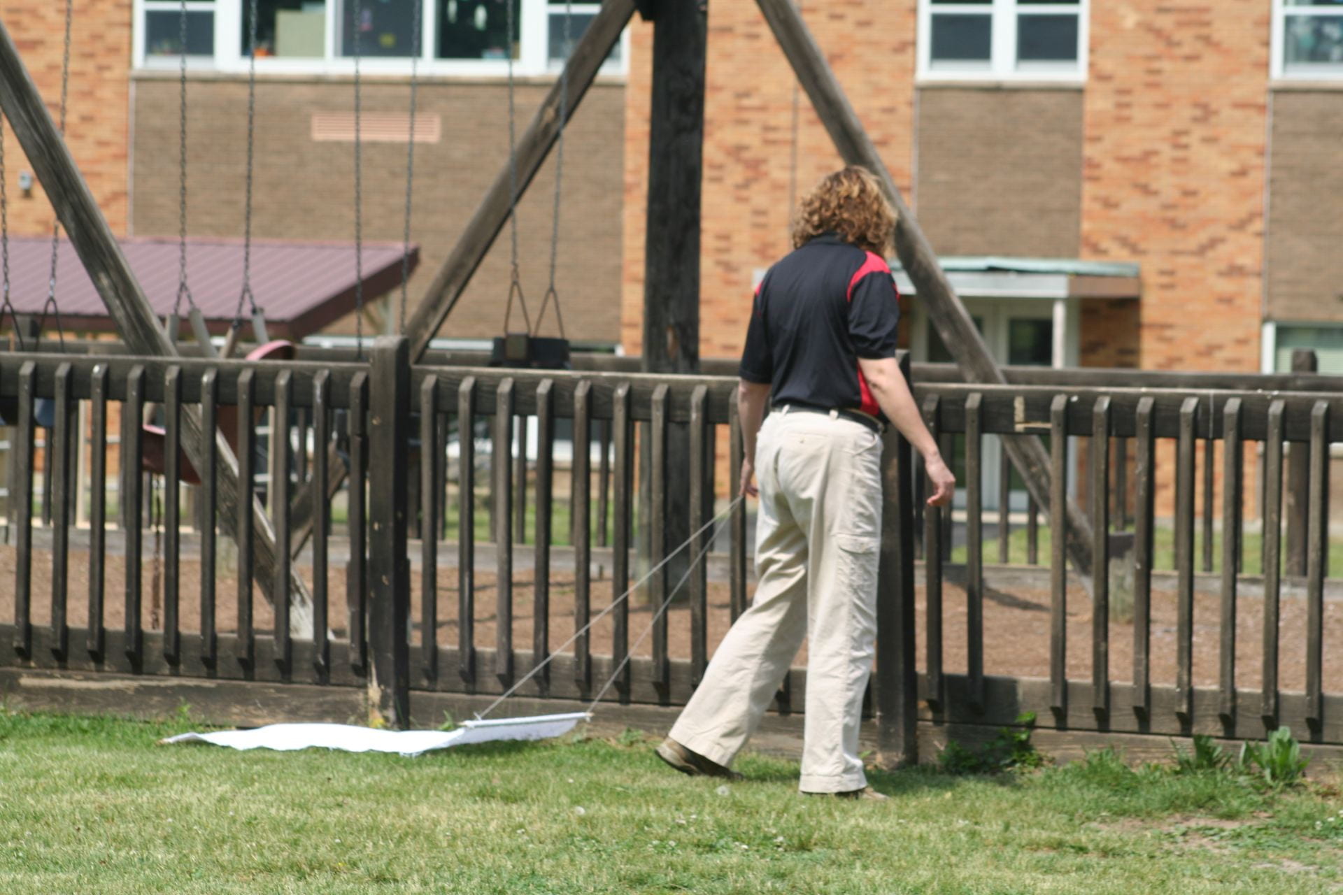 photo shows Joellen Lampman using a tick drag on school property to monitor for ticks