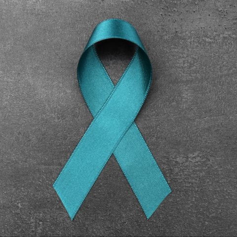 Sea-green ribbon on grey background. Ovarian cancer and gynecological disorders concept