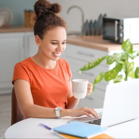 Young woman using laptop for online learning at home