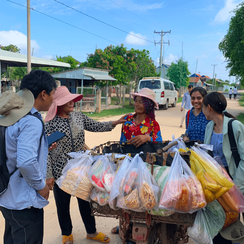 Shreya Chitnavis talking with a food vendor in Cambodia