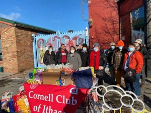 Cornell alumni at table in downtown Ithaca volunteering on Cornell Cares Day