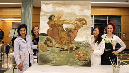 three sisters in soil artists pose with finished canvas