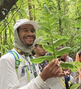 Josh Felton holding a fern in the forest of Costa Rica