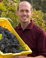 Matthew Clark headshot, holding a bin of grapes